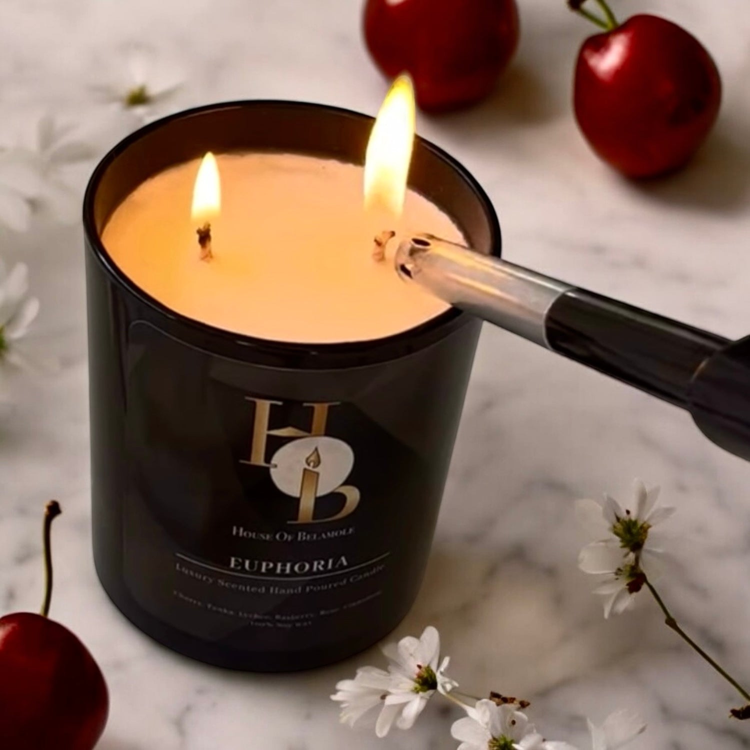 Best-selling Euphoria 2-wick scented soy candle lit with fruity spicy scent notes of cherry, raspberry, and cinnamon, creating a warm, relaxing glow and luxurious home fragrance experience.
