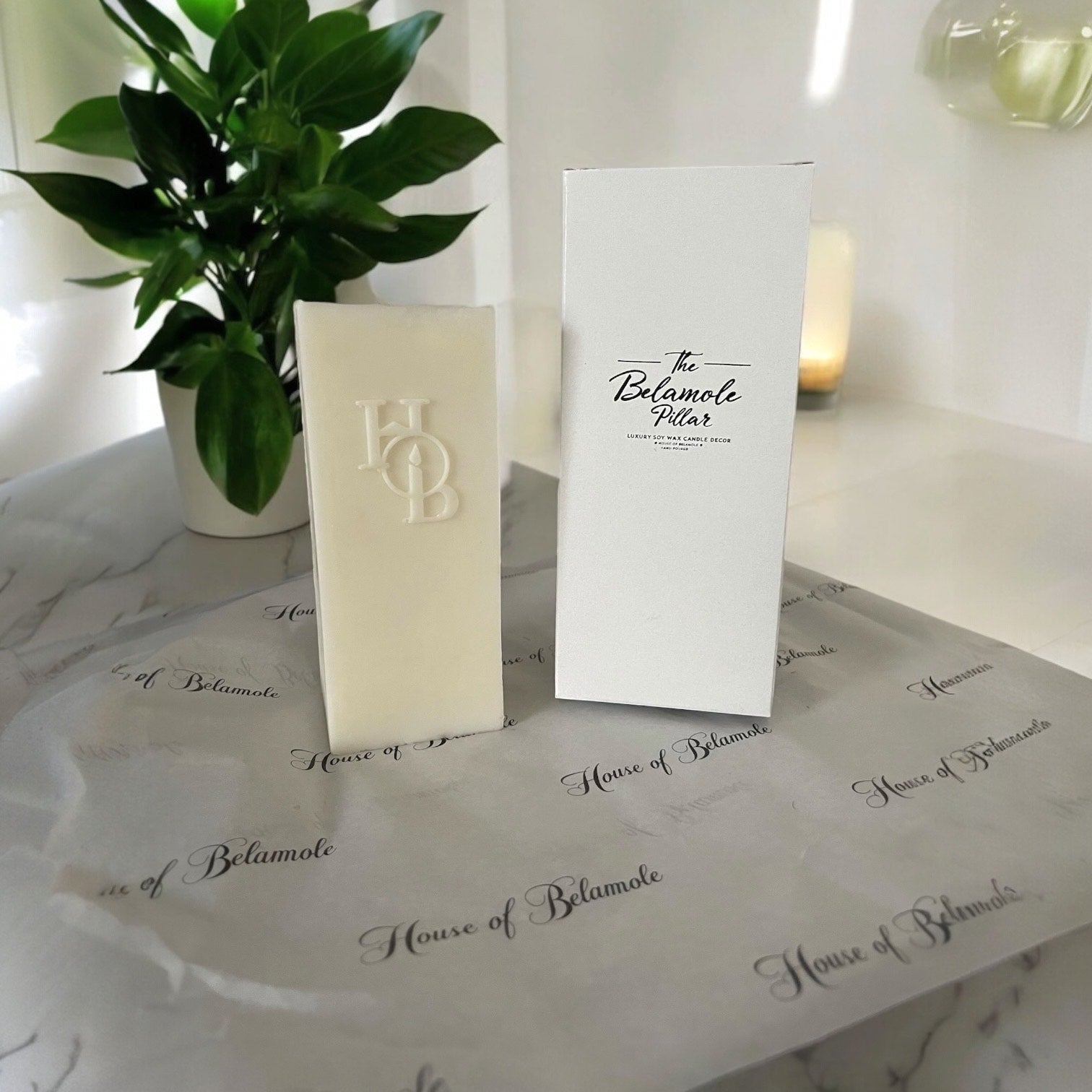 Belamole Pillar candle positioned next to a luxury gift box beside wellness accessories.