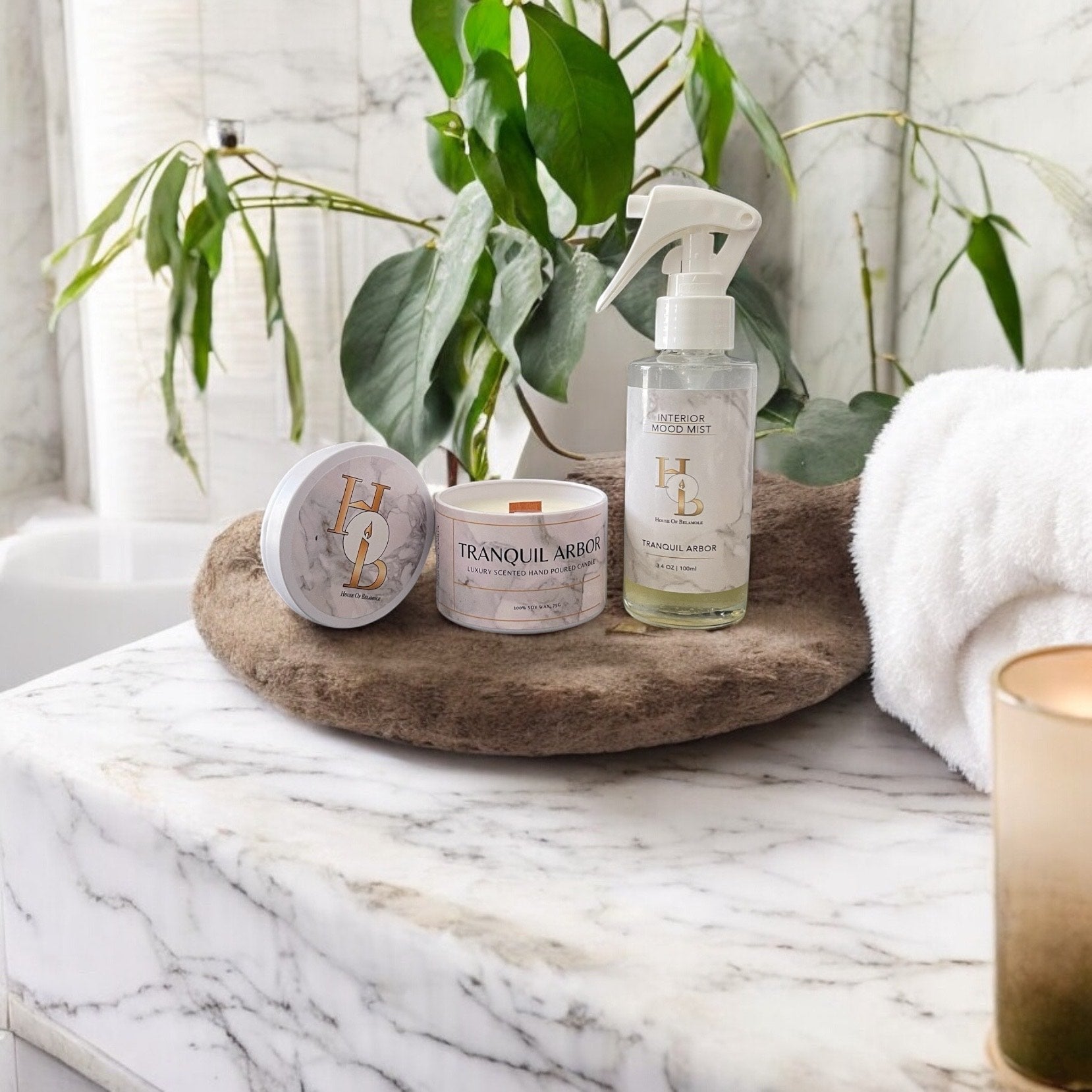 Tranquil Arbor woodwick candle and alcohol-free room mist with calming oudh, rose, and sandalwood notes, styled in a luxury bathroom to create a spa-like home fragrance experience and soothing interior atmosphere.